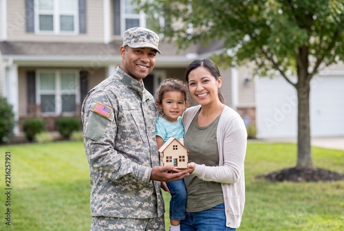 Military Family Holding Model House Outside Suburban Home for VA Loan
