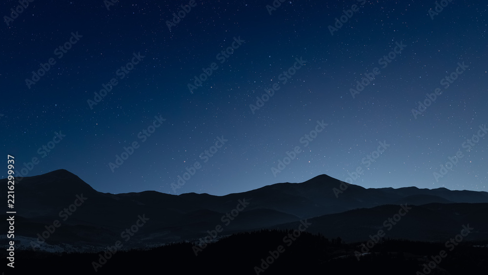 Fototapeta premium Glowing Christmas star above a peaceful mountain landscape