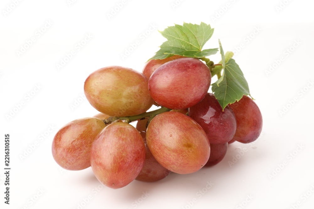 Fototapeta premium Bunch of fresh ripe grapes with green leaves on white background