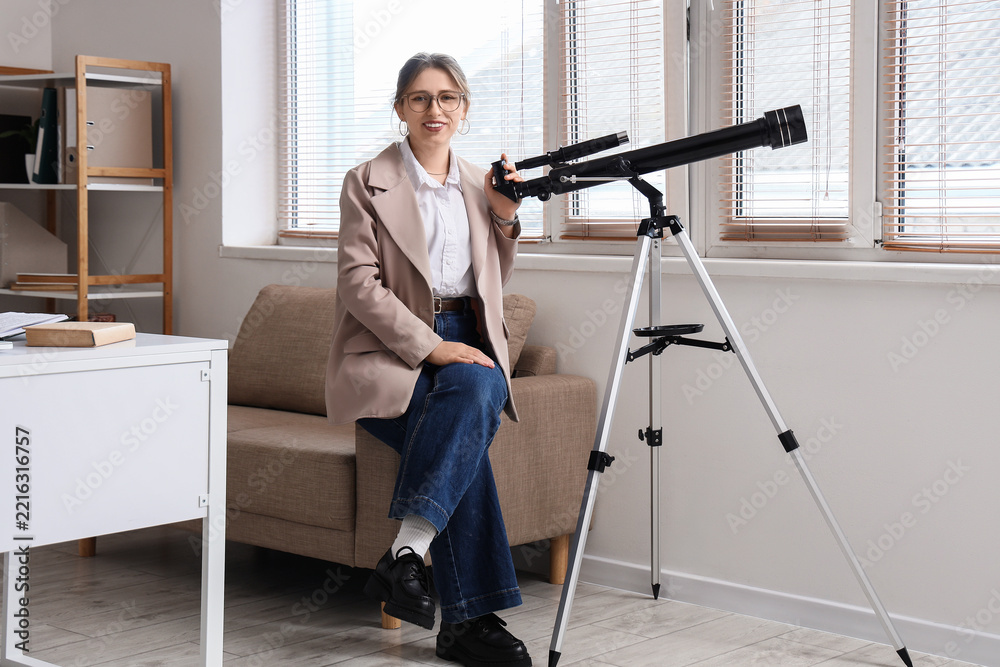 Fototapeta premium Scientific discovery and research, young woman with telescope in office for astronomy education and space exploration study