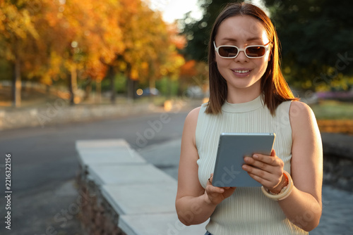 Digital nomad lifestyle and remote work, young woman using a tablet in an aut...