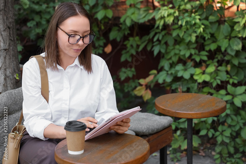 Digital nomad lifestyle and remote work, young woman using a tablet in an out...