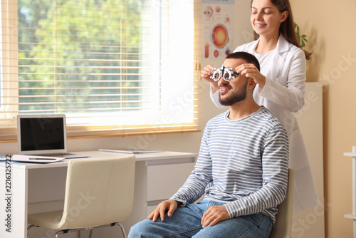 Eye exam and vision care, optometrist testing patient eyesight with trial fra...