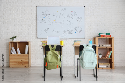 Homeschooling and remote learning, student desks with laptop and backpacks in...