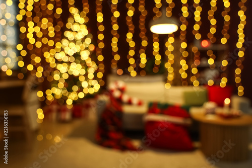Blurred view of dark living room with glowing Christmas tree and sofa