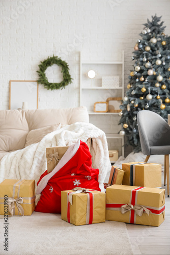 Interior of living room with sofa, Santa bag and Christmas presents