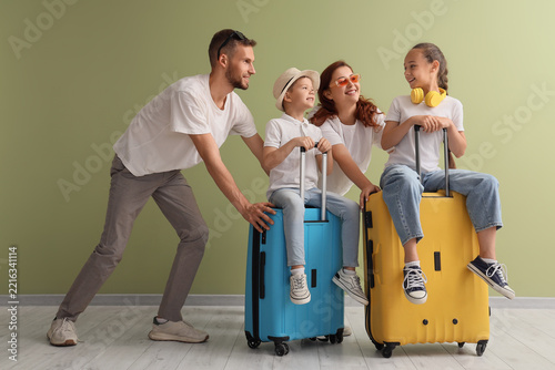 Family travel and summer vacation, happy parents with children sitting on sui...