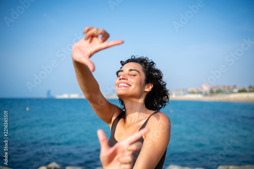 Woman framing sea view with hands enjoying summer in Barcelona