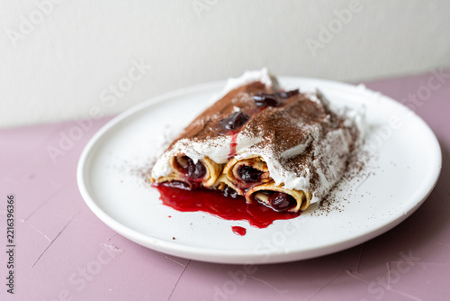 Traditional Moldovan layered dessert Căciula lui Guguță with sour cherries and cream 