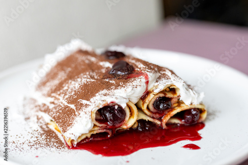 Traditional Moldovan layered dessert Căciula lui Guguță with sour cherries and cream 