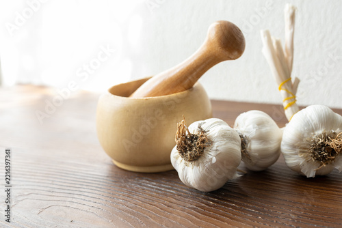 garlic mortar and pestle with fresh garlic cloves close up
