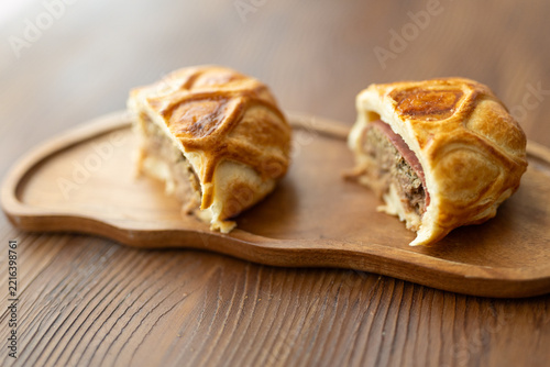 Gourmet Beef Wellington pastry sliced on a rustic wooden board