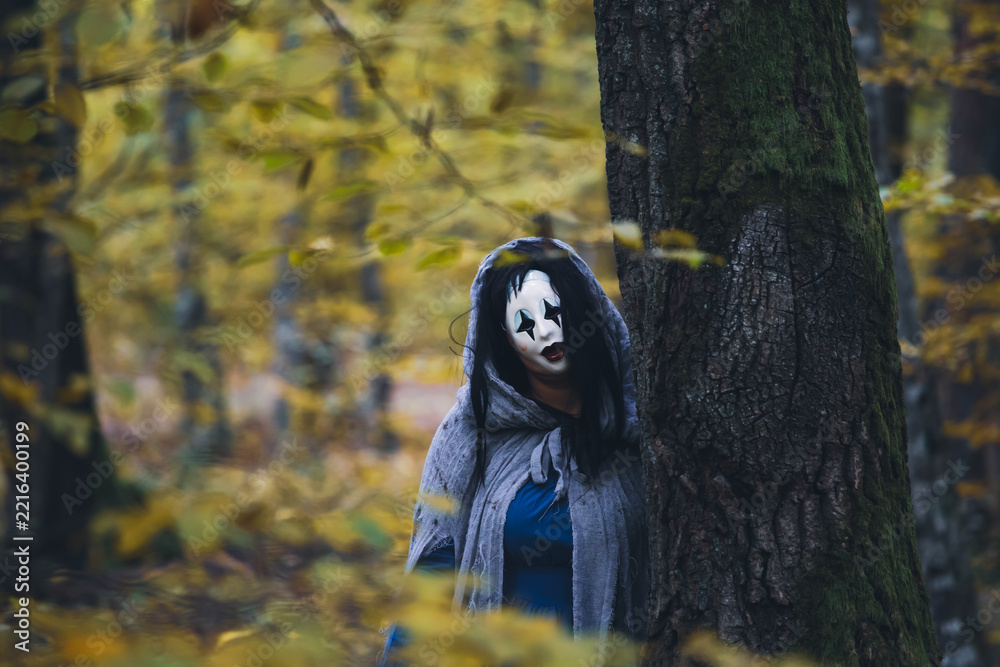 Naklejka premium Horror background of a ghostly figure in enchanted a forest on a moody autumn day.