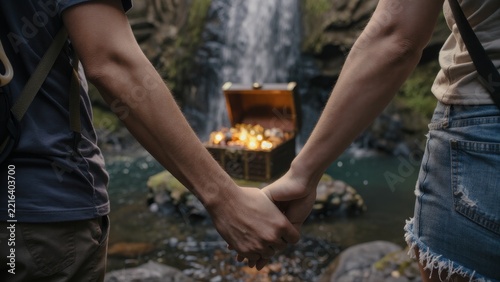 Couple Holding Hands Near Waterfall with Treasure Chest Scene