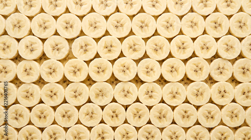 Freshly sliced banana rounds arranged neatly in organized pattern