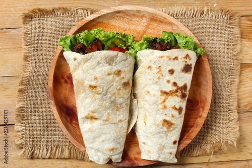 wrapped tortilla on plate on the table. Top view