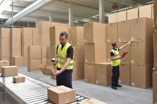 Worker in a warehouse in the logistics sector processing packages on the assembly line  - transport and processing of orders in trade