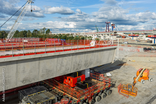 Aerial view of a large concrete bridge segment being transported by a heavy-duty vehicle at a high speed rail construction site in the United Kingdom.
