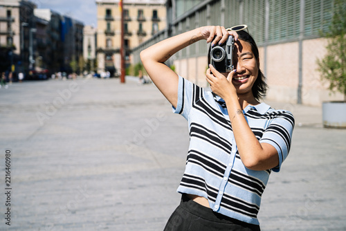 Asian woman smiling taking a picture with vintage camera