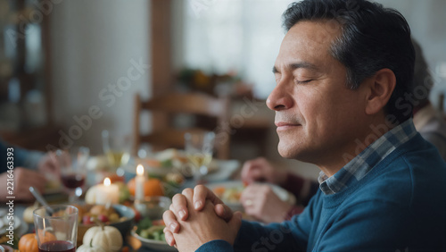 elderly Mexican-American man sitting at a Thanksgiving table, sharing a quiet moment of gratitude and prayer before dinner; copy space for Thanksgiving text