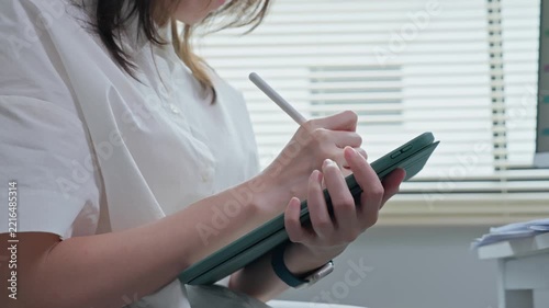 Close Up of Woman Writing on Digital Tablet with Stylus Pen