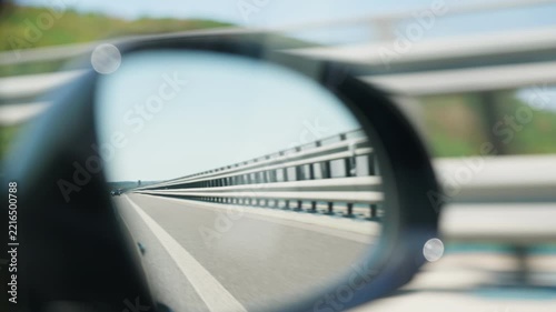 Highway reflected in car side mirror road barrier