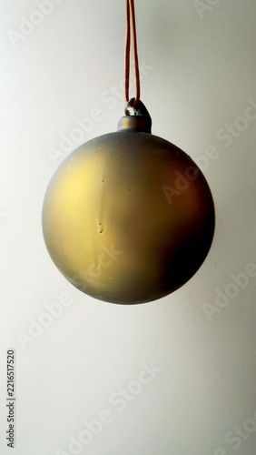 Glass Christmas Bauble Hanging in Soft Light Vertical