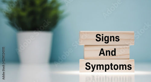 Minimalist Wooden Blocks Displaying 'Signs and Symptoms' Text with Indoor Plant Background