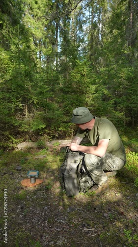 Hiker unpacking a backpack to set up a picnic in a forest