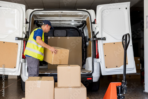 Man preparing outgoing parcels for daily delivery inside warehouse