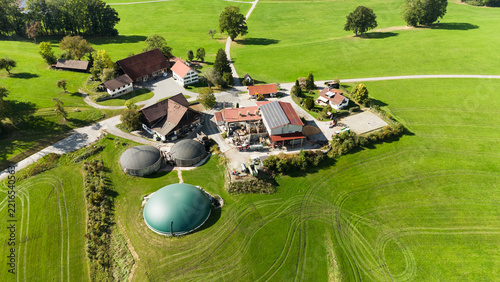 Aerial view of a farm with biogas plant and green pastures