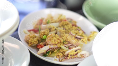 4K Delicious Thai stir-fried seafood with curry powder and fluffy egg served on white plate, representing authentic Thai cuisine and popular seafood dish.