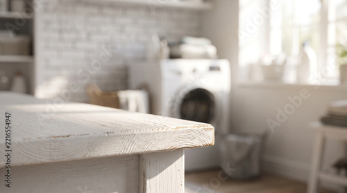 Empty white table top in bright modern laundry room interior

