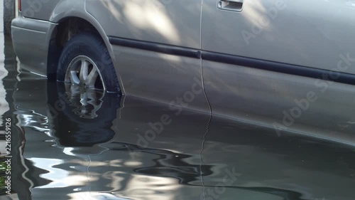 Close-Up of Rusted Vehicle Damaged and Submerged in Floodwater, Total Loss Car Reflecting Nearby Wreckage