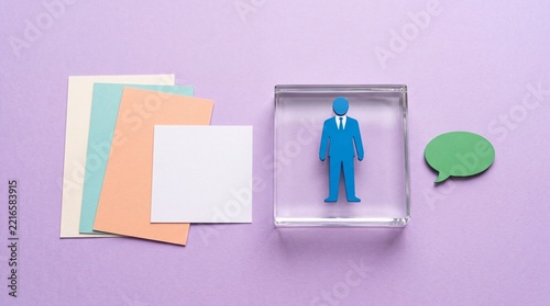 Blue businessman figure standing inside a glass block near colorful