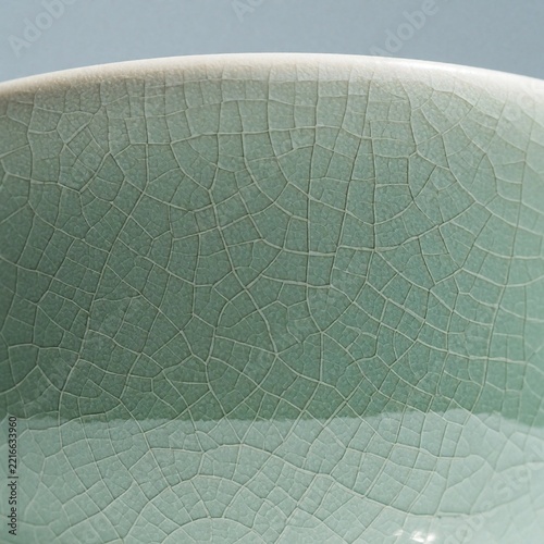Macro close-up of a celadon ceramic bowl with a crackle glaze