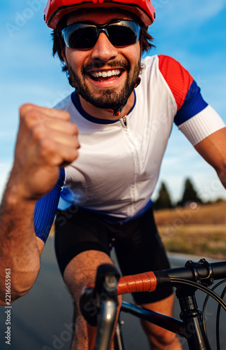 Close up shot of happy cyclist gesturing fist pump while riding.