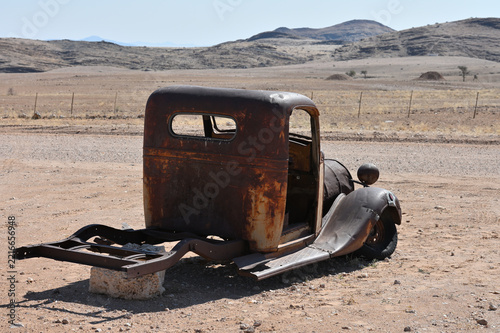 Old rusty car near a road in the Namib Desert