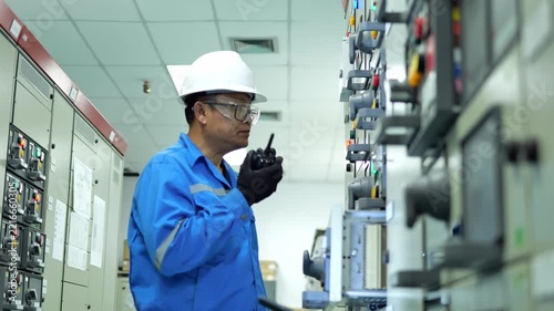 Professional engineer monitoring electrical control cabinets in a high-tech industrial facility for reliable power distribution.