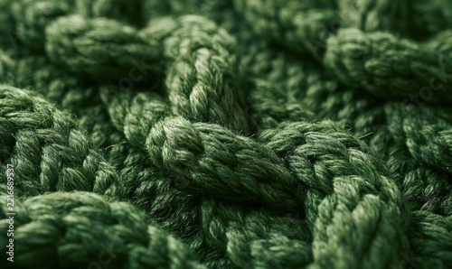 Green knitted fabric texture with visible stitches and fibers