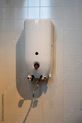 Vintage Wall-Mounted Water Heater With Faucets and Knobs