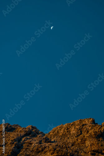 Fotografie Luna calante nel cielo blu sopra le rocce illuminate dall'alba, Dolomiti di Bren