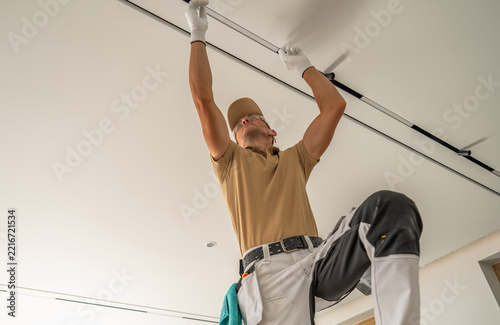 Worker installing a ceiling curtain track