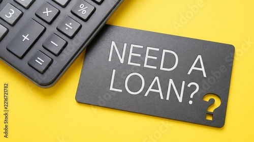 Black card with need a loan text and calculator on yellow background for financial planning and business credit concepts