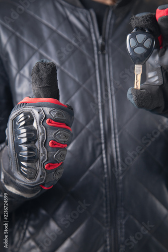 Motorbiker holding a key of motorcycle.