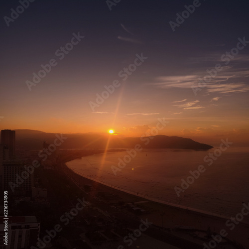 Sunrise over Quy Nhon, Vietnam, from aerial level looking toward the coastline. Peaceful tropical coastal landscape panorama