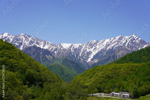 北アルプス　残雪の鹿島槍ヶ岳と爺ヶ岳　新緑の里山	