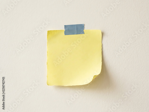Yellow sticky note taped to a wall