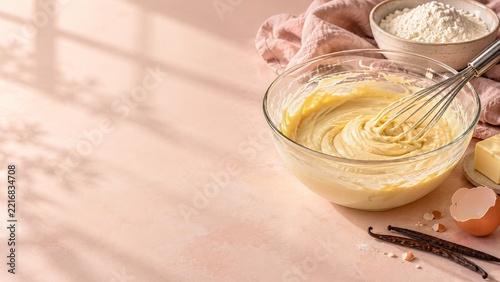 Cake Batter and Whisk with Eggs and Butter on a Peach Baking Counter