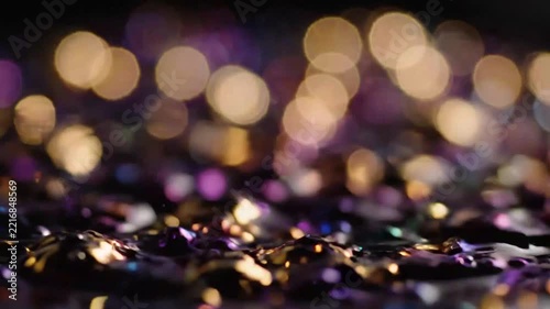 Close-up of water droplet hitting a dark surface with shimmering reflections